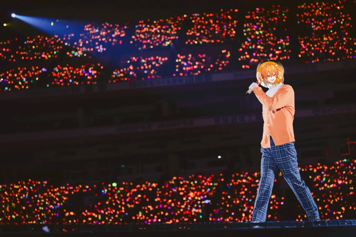 スポットライトを浴びたステージ上のパフォーマーと、無数のペンライトで彩られた観客席