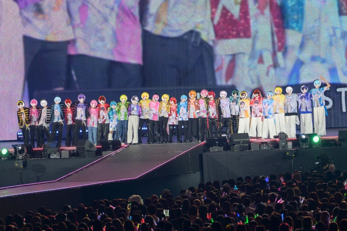 ステージ上でパフォーマンスを行うグループと、サイリウムを振る大勢の観客