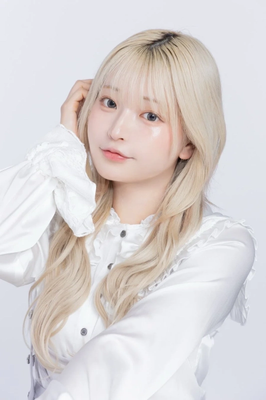 白いフリルブラウスを着た金髪の女性のポートレートです。