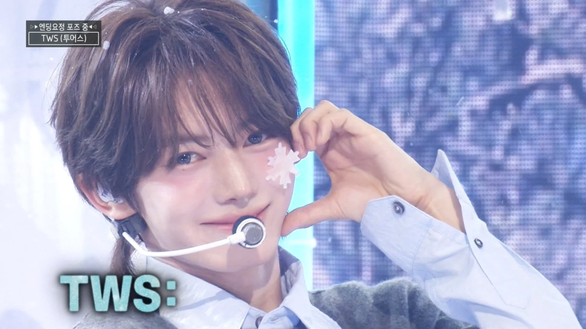 TWSメンバーが雪の結晶シールを頬に貼り、指ハートをするクローズアップ