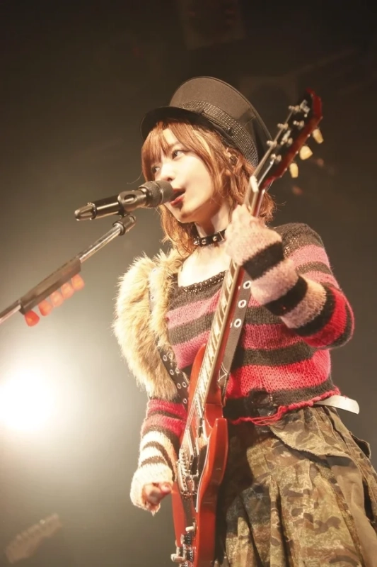 ボーダーの衣装でギターを演奏する愛美さん