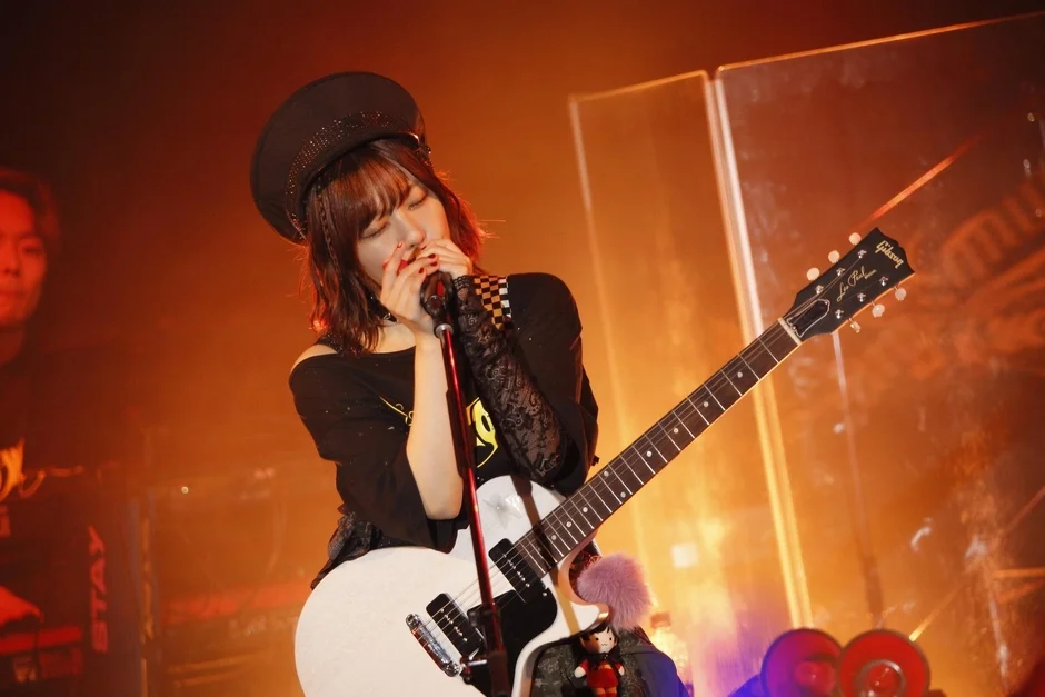 帽子をかぶりギターを弾く愛美さん