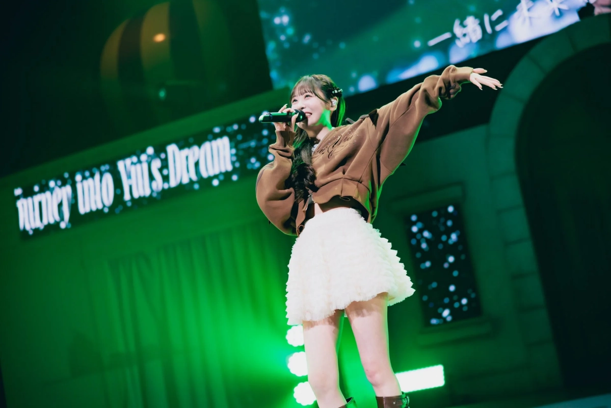 緑色の照明の中で歌唱する櫻井優衣