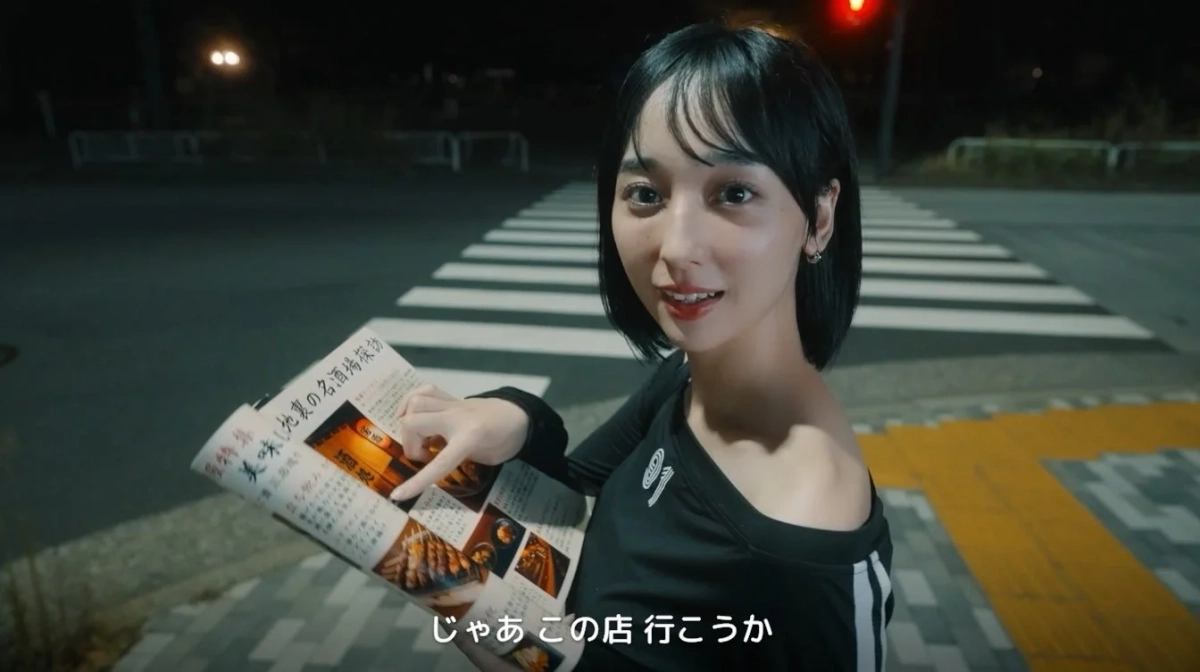 夜の街で雑誌を読む女性