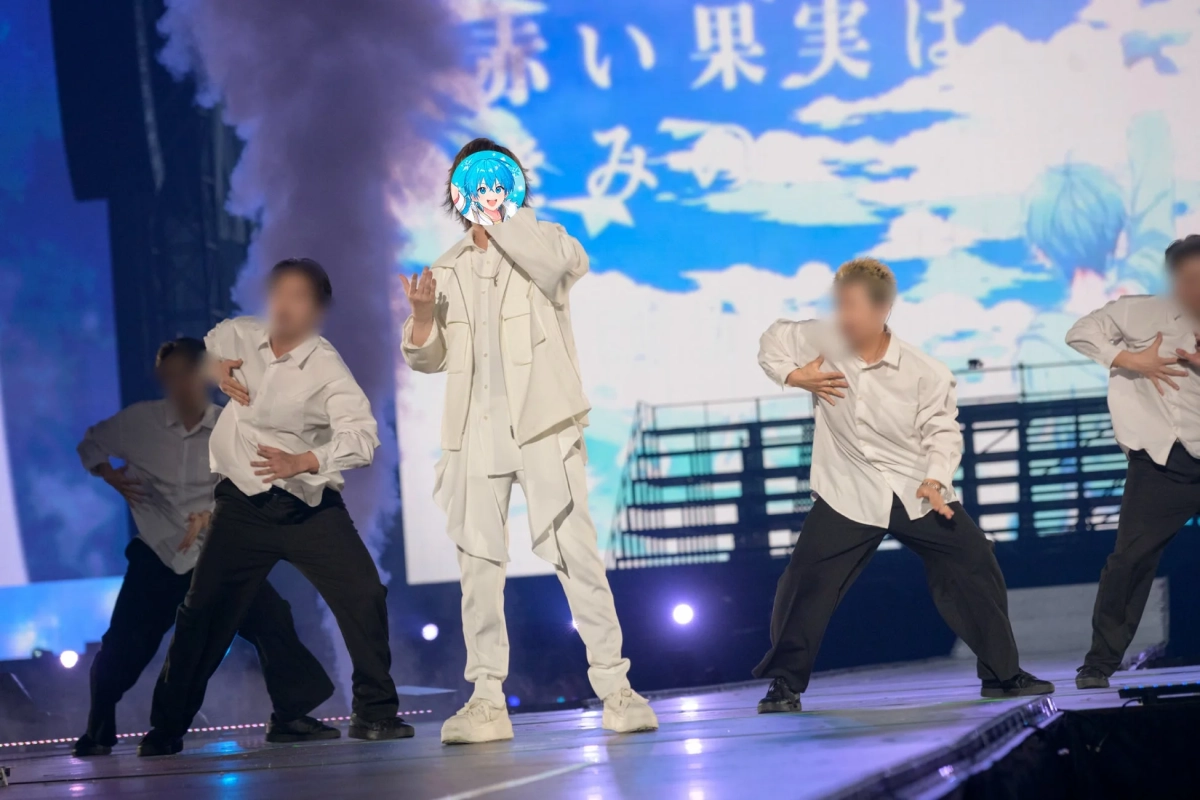 ステージ上で白い衣装のパフォーマーがバックダンサーと共にダンスを披露