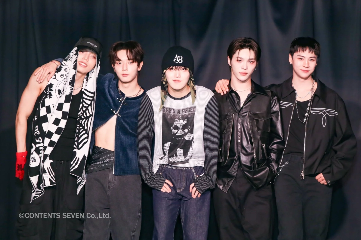 黒を基調とした衣装でポーズを決めるCMDM