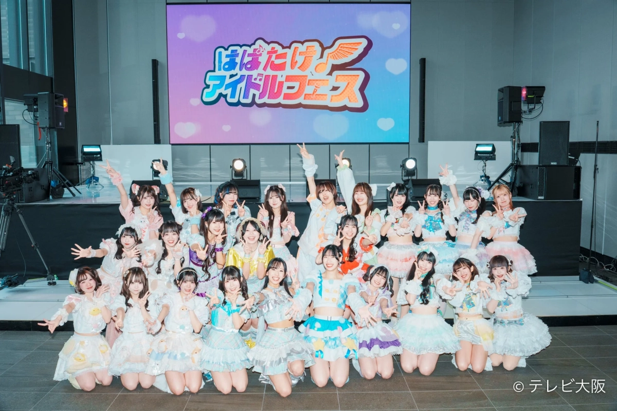 多数のアイドルグループが集合写真を撮影している様子