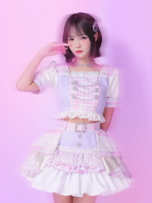 ピンクとラベンダー色のフリルやレースが特徴的なアイドル衣装を着用した若い女性