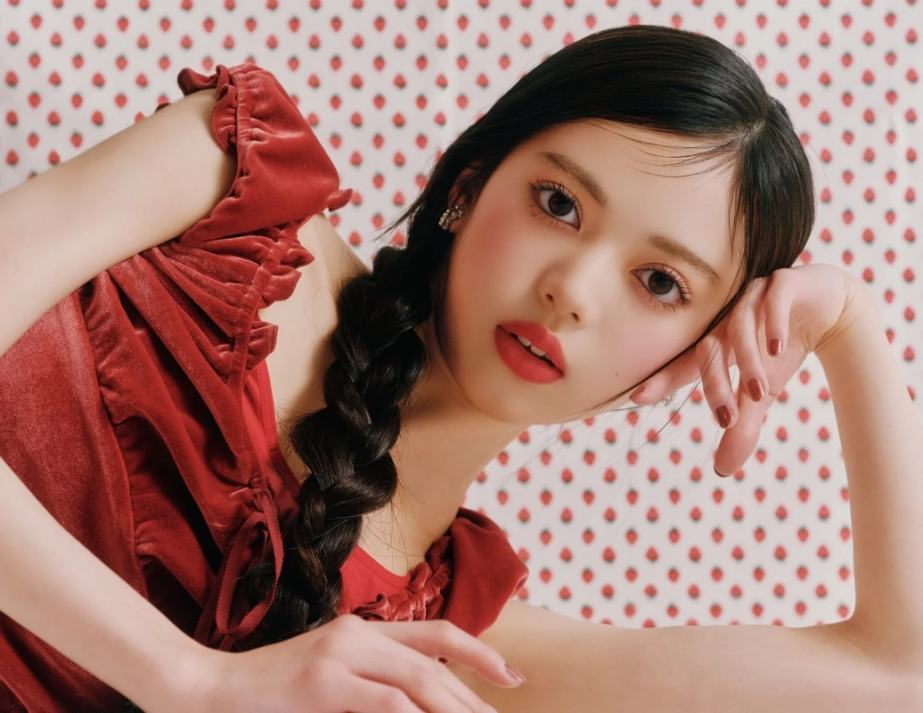 赤いベルベットの服を着て三つ編みの髪をした若い女性