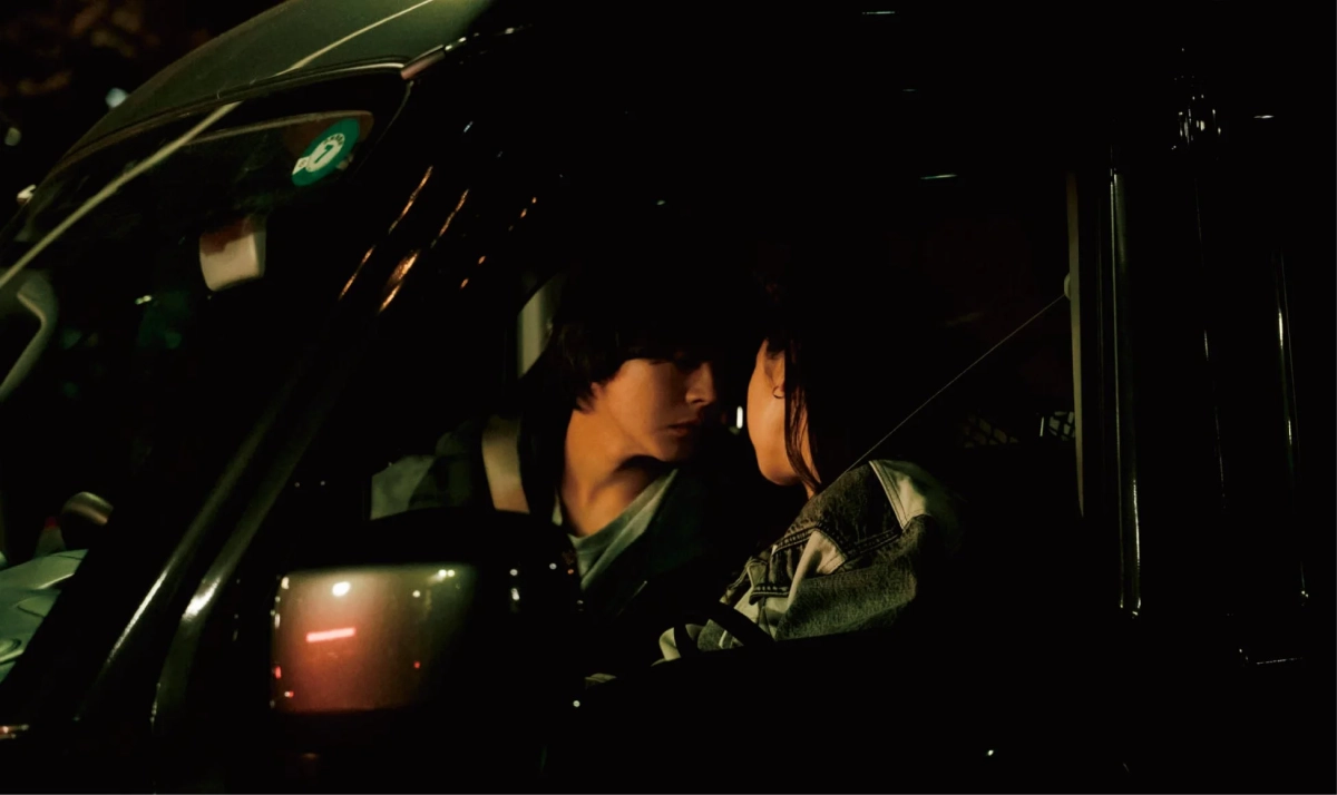 車内で顔を寄せ合うカップル