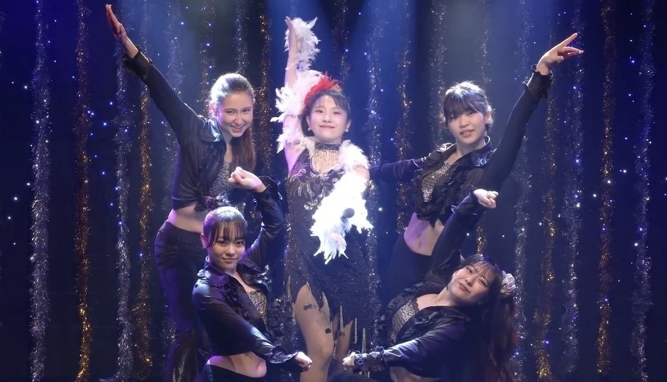 華やかなステージでパフォーマンスする女性グループ