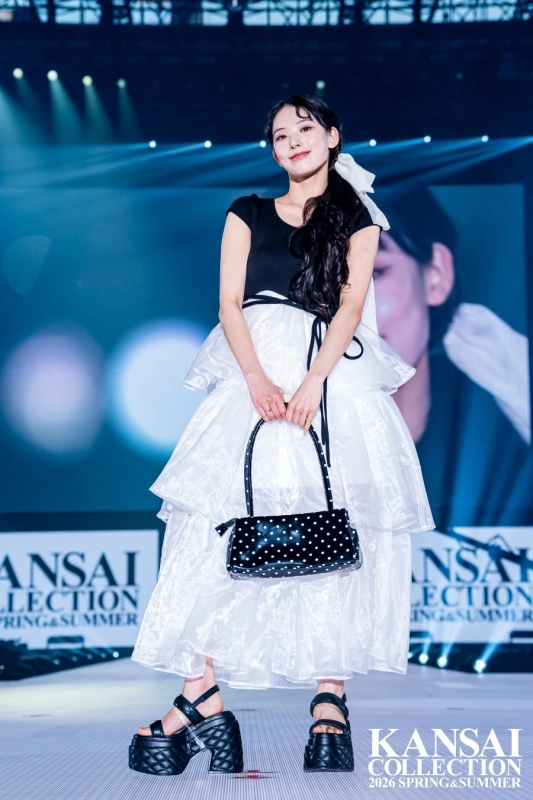 ファッションショーのランウェイでポーズをとる若い女性モデル