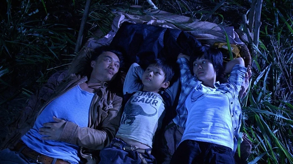 夜の草むらに横たわる家族