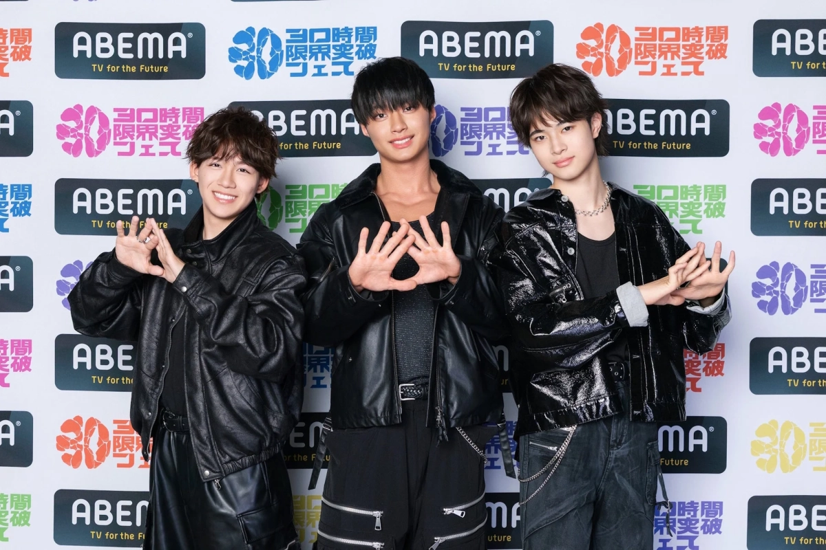 黒いレザージャケットを着用した3人の若い男性が、ABEMAのロゴと「30時間限界突破フェス」の文字が描かれた背景の前で笑顔でポーズをとっています。