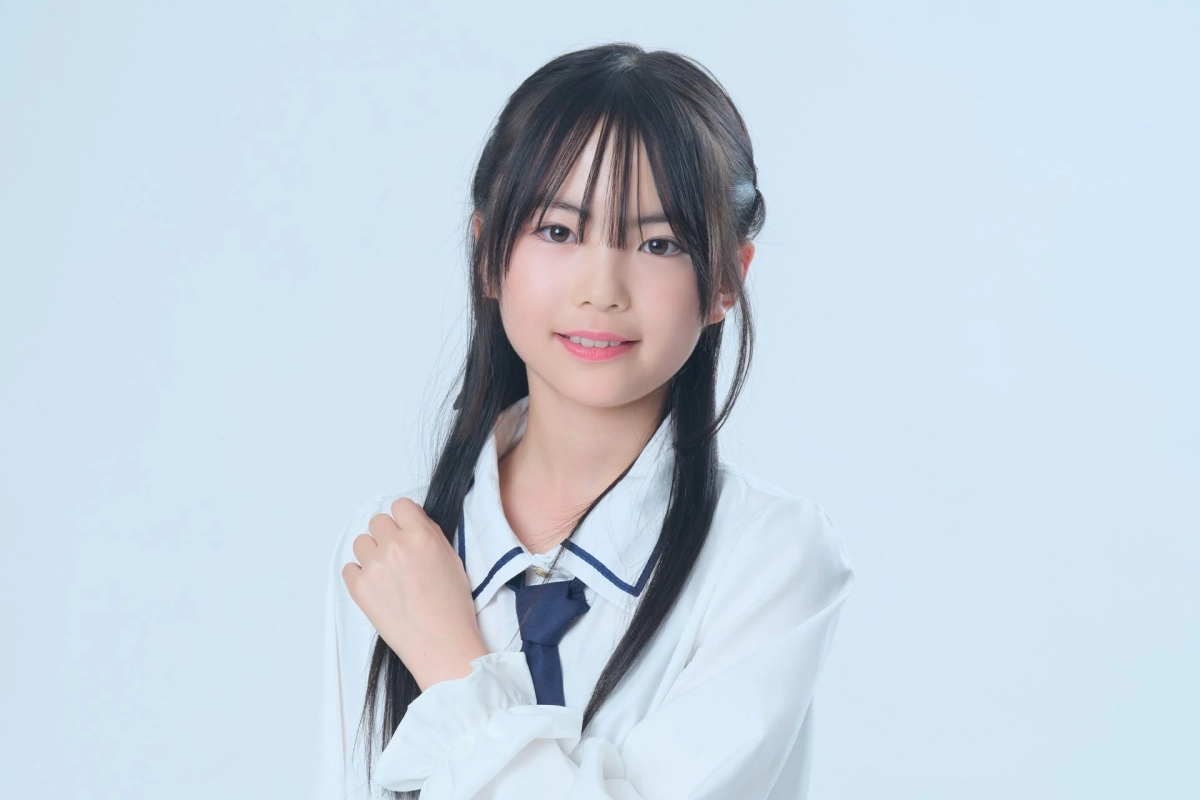 白い背景の前で優しく微笑む坪田 唯愛さん