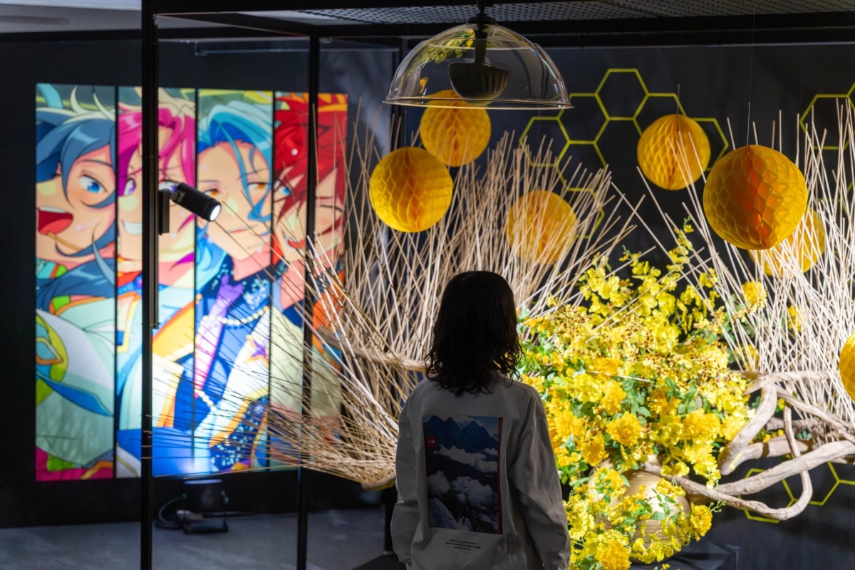 アニメキャラクターのパネルと黄色い花や提灯、竹のオブジェが飾られた展示空間