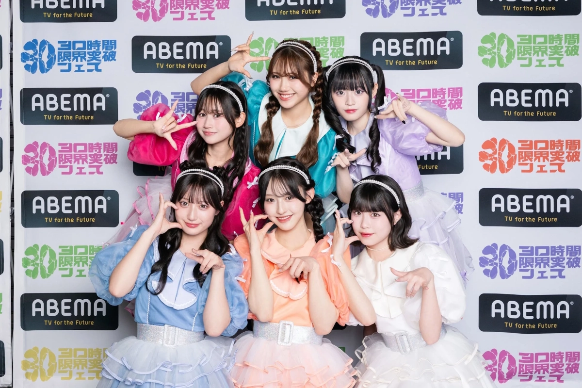 カラフルなフリル衣装を身につけた6人の女性アイドルグループが、ABEMAのロゴと「30時間限界突破フェス」のバナーを背景に、笑顔で可愛らしいポーズを取っています。