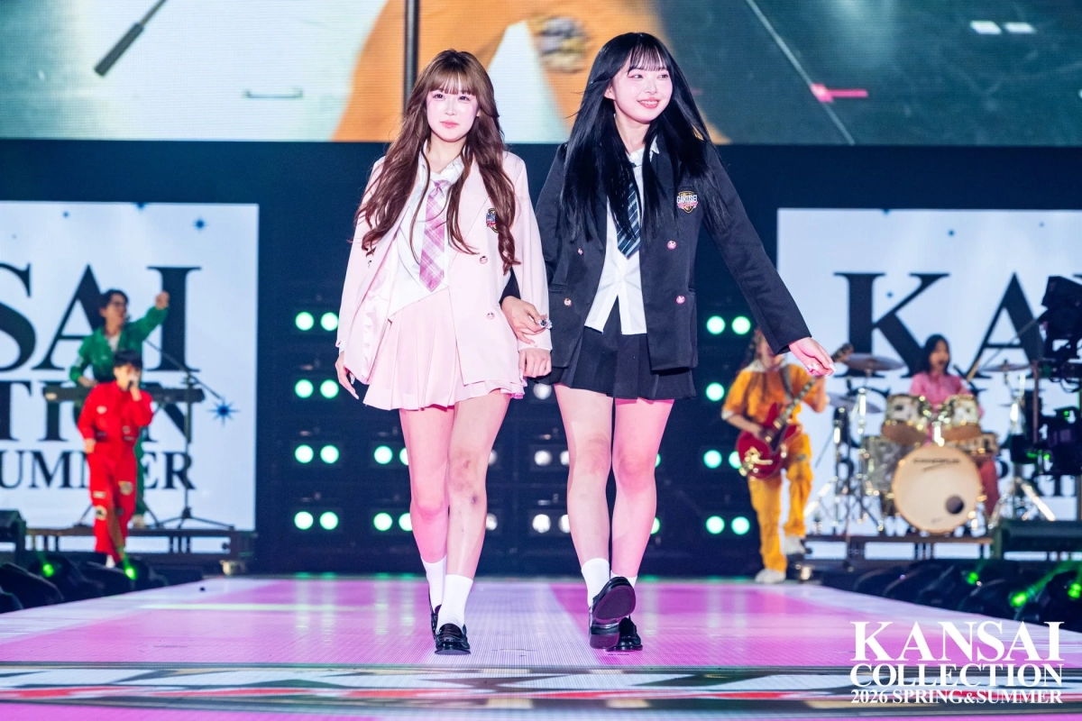 ピンクと黒の制服風の衣装を着用した2人の若い女性モデル