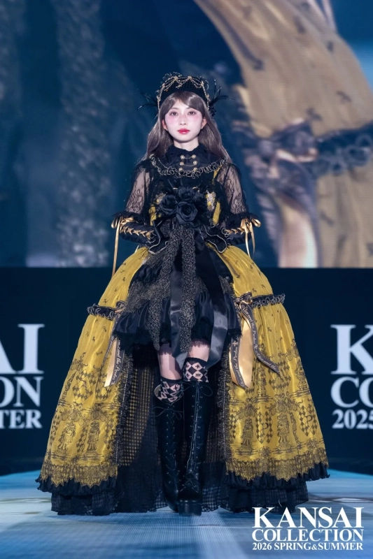 黒と黄色の豪華なゴシックロリータ風ドレスを着用し、王冠とブーツで飾られている