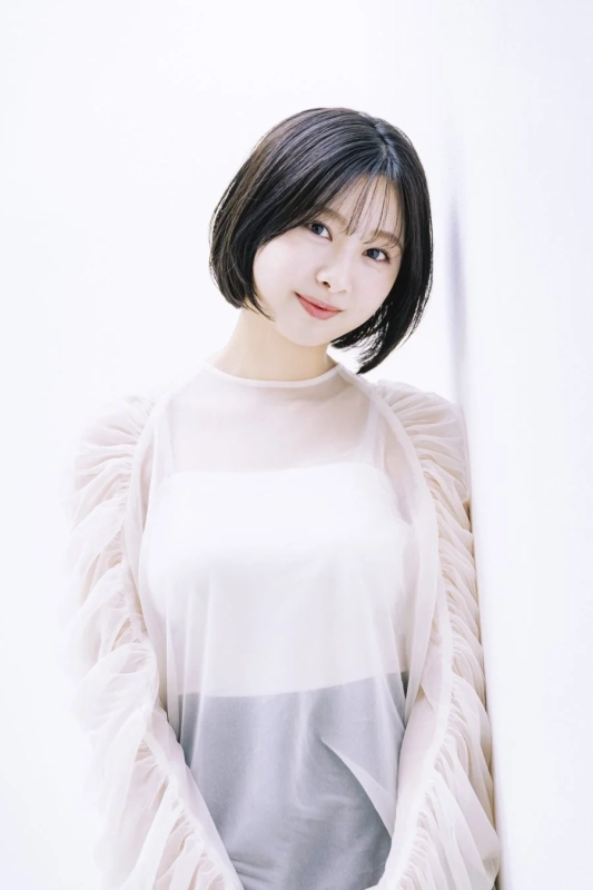 白い壁に寄りかかり微笑む富田鈴花さん