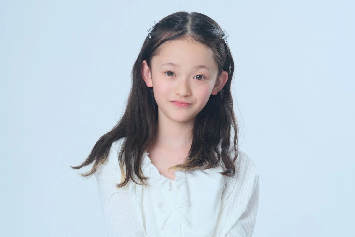 白いヘアクリップをつけた佐々木 莉子さんがカメラに向かって微笑む