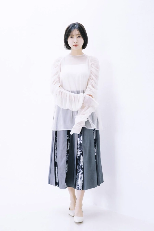 白いブラウスとグレーのスカートを着用した富田鈴花さん