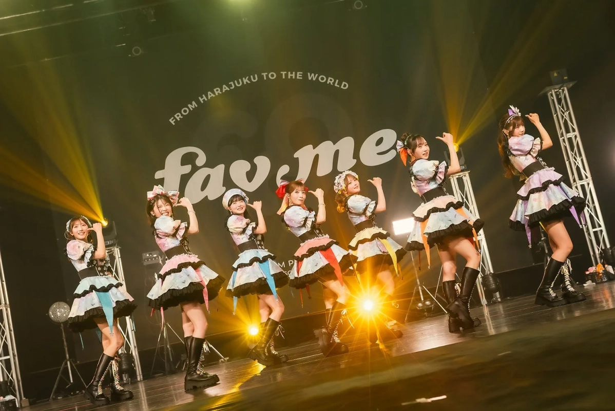 スポットライトを浴びて笑顔でパフォーマンスするfav me