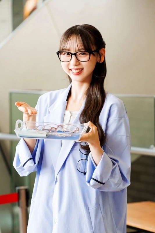 Zoffの白衣を着て眼鏡を差し出す泉綾乃さん