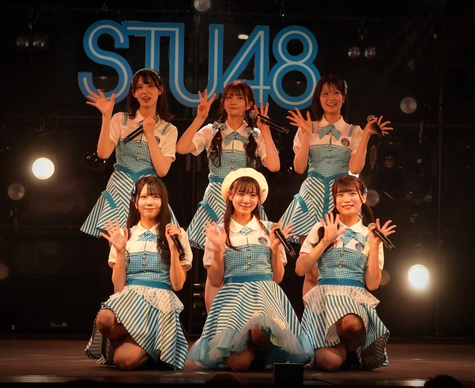 STU48のメンバー6人が、青と白のストライプ柄の衣装を着てステージ上でポーズをとっています