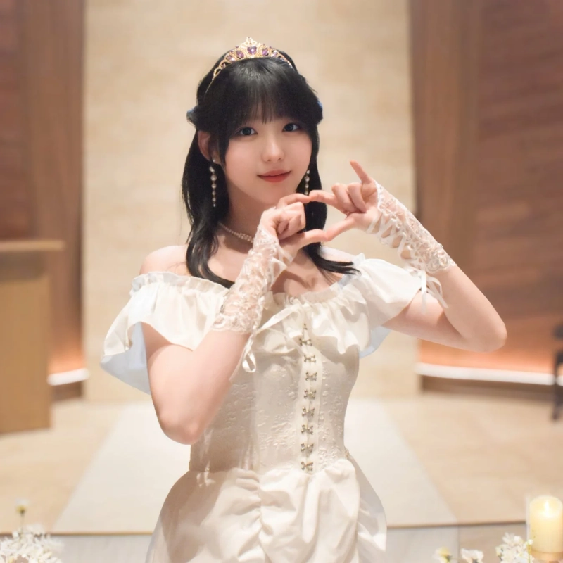 白いオフショルダードレスとティアラを身につけた瑚春