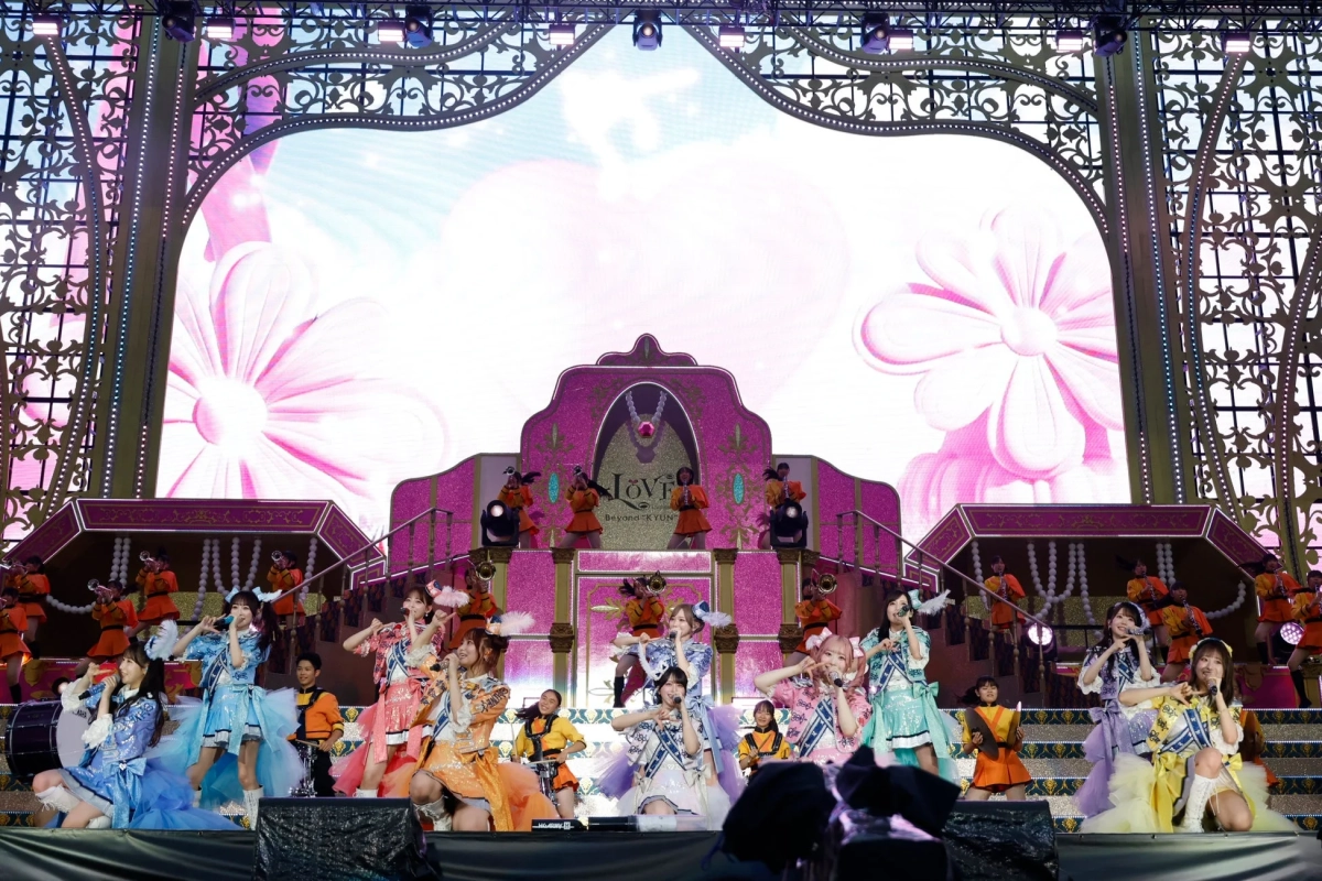 カラフルな衣装のアイドルグループが華やかなステージで歌い踊るライブ