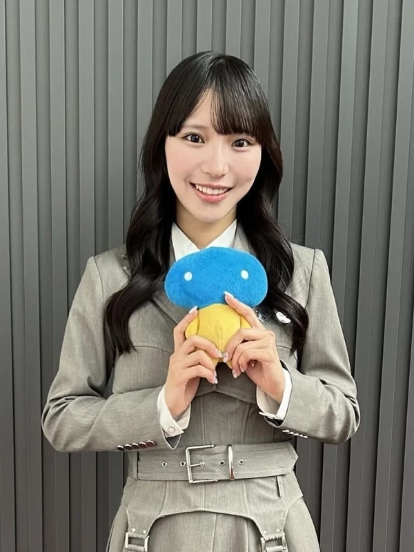 青と黄色の可愛らしいぬいぐるみを持っているACOさんのポートレート