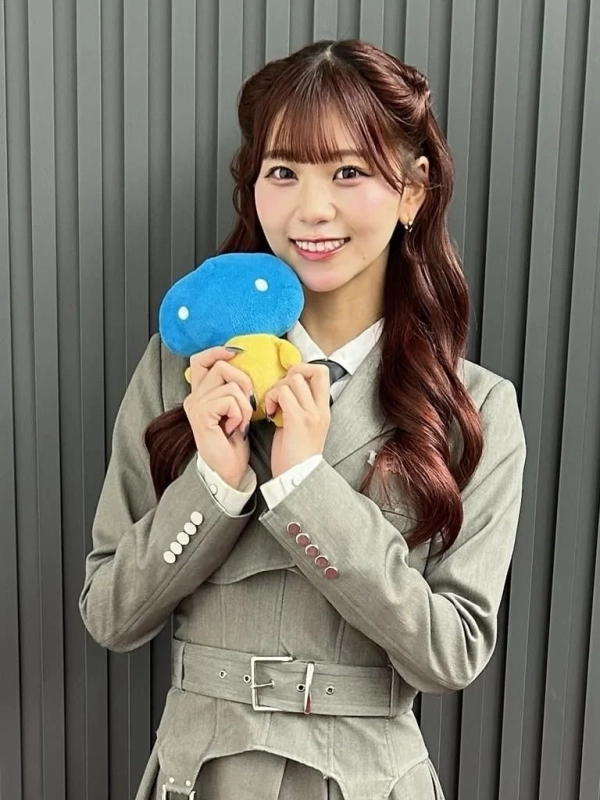 青と黄色の可愛らしいぬいぐるみを胸の前で抱えるNICOさんのポートレート