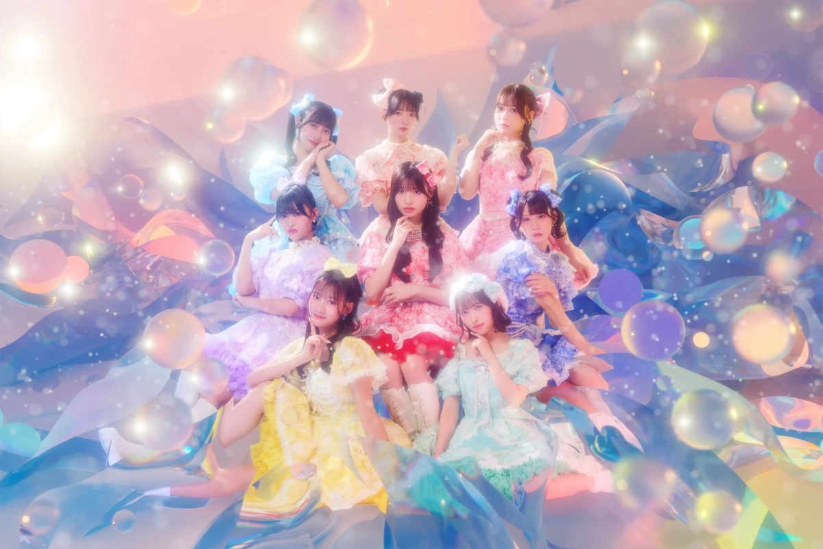 パステルカラーのフリル衣装を着た8人の女性アイドルグループが、泡や光が輝く幻想的な背景の中でポーズをとっている画像です。可愛らしく夢のような雰囲気です。