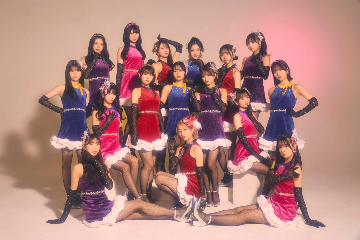 きらびやかなミニドレスを着用した15人の女性アイドルグループの集合写真