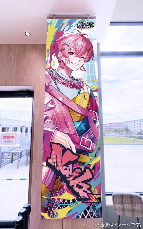 屋内の柱に設置された、ピンク髪の男性アニメキャラクターが描かれたカラフルな縦型バナー。