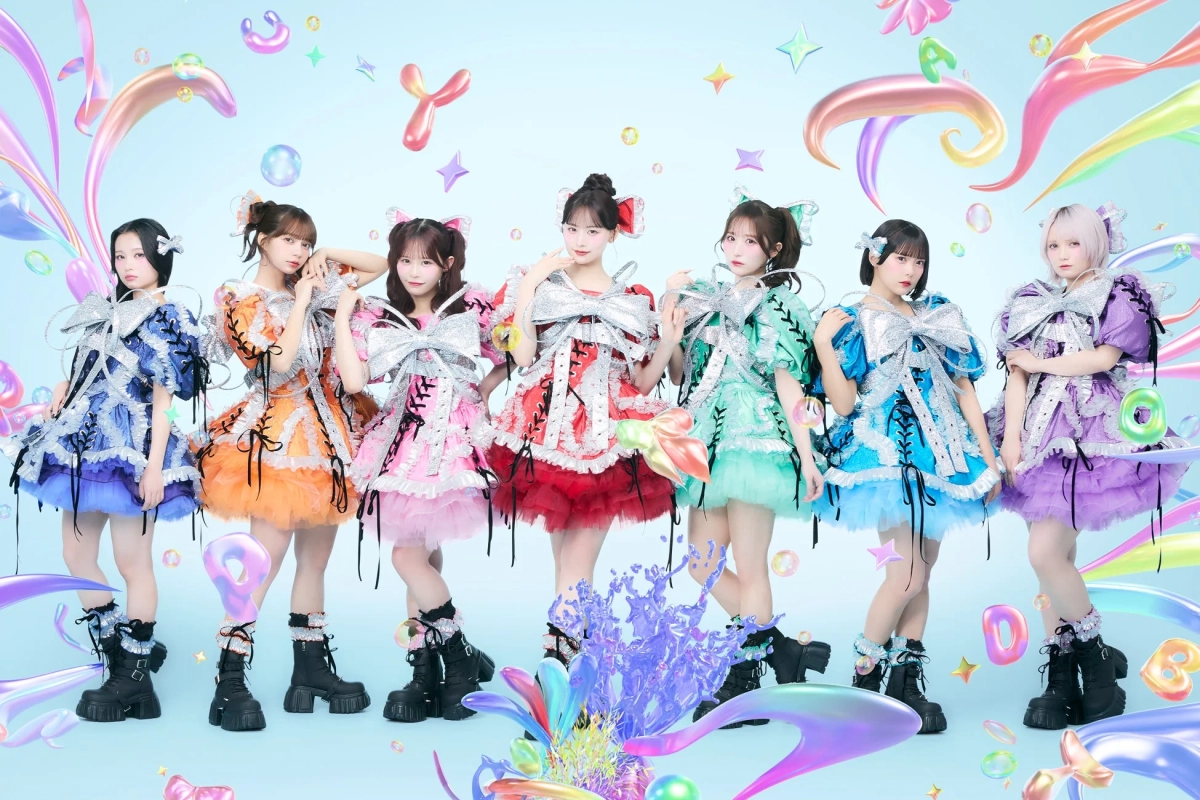 カラフルなフリルドレスと大きなリボンを身につけた7人の若い女性アイドルグループ