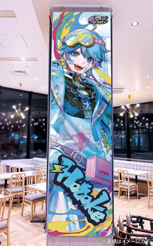 モダンなカフェの店内に設置された、青い髪とゴーグルが特徴のカラフルなアニメ男性キャラクターの縦型バナー。