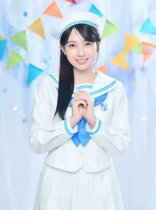 白いセーラー服とベレー帽を着用した若い女性が、手を組んで笑顔でポーズをとっています。背景にはカラフルなガーランドが飾られており、明るく可愛らしい雰囲気の画像です。