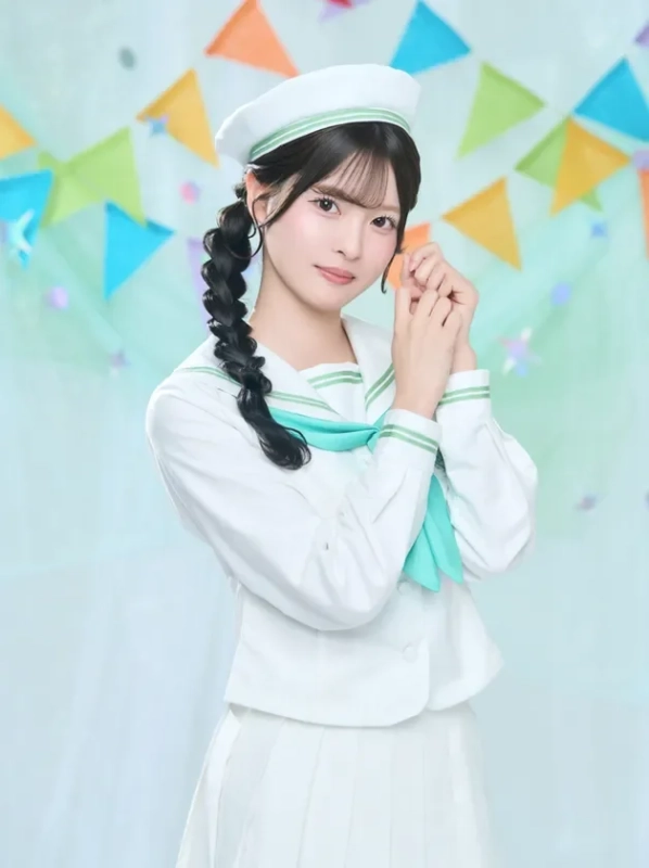白いセーラー服にベレー帽を着用した若い女性が、カラフルなガーランドが飾られた背景の前で優しく微笑んでいます。三つ編みの髪型が特徴的です。